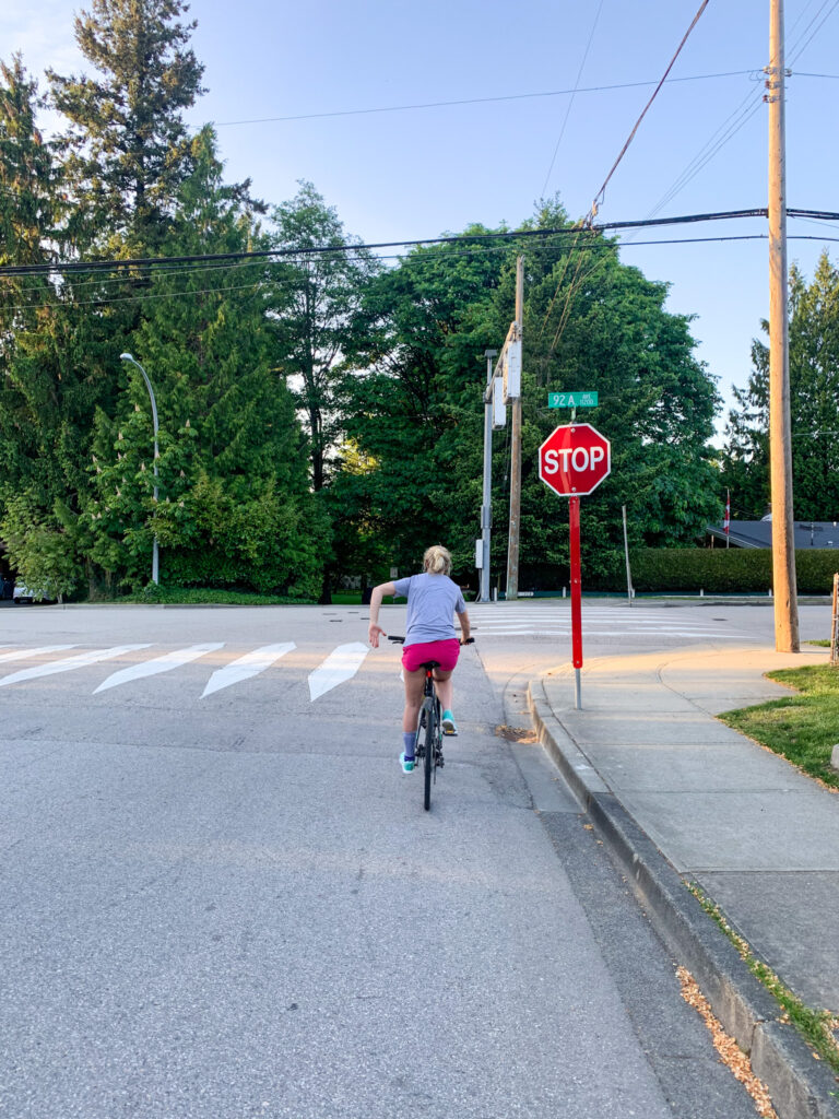 Photo of a cyclist demonstrating the appropirate hand signals of stopping. Located along the popular 112th street bike route in North Delta. 
